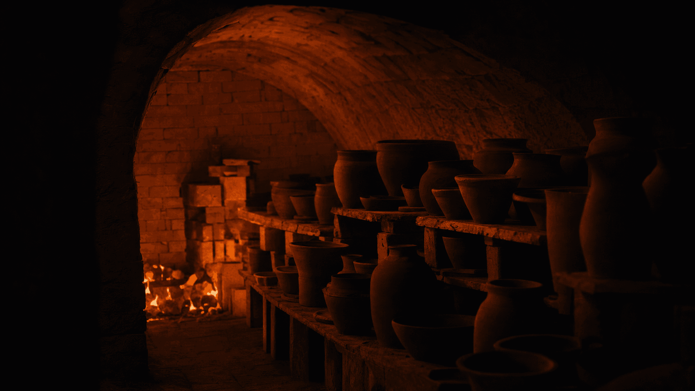 Interior of a wood-fired kiln glowing with embers, vessels in silhouette